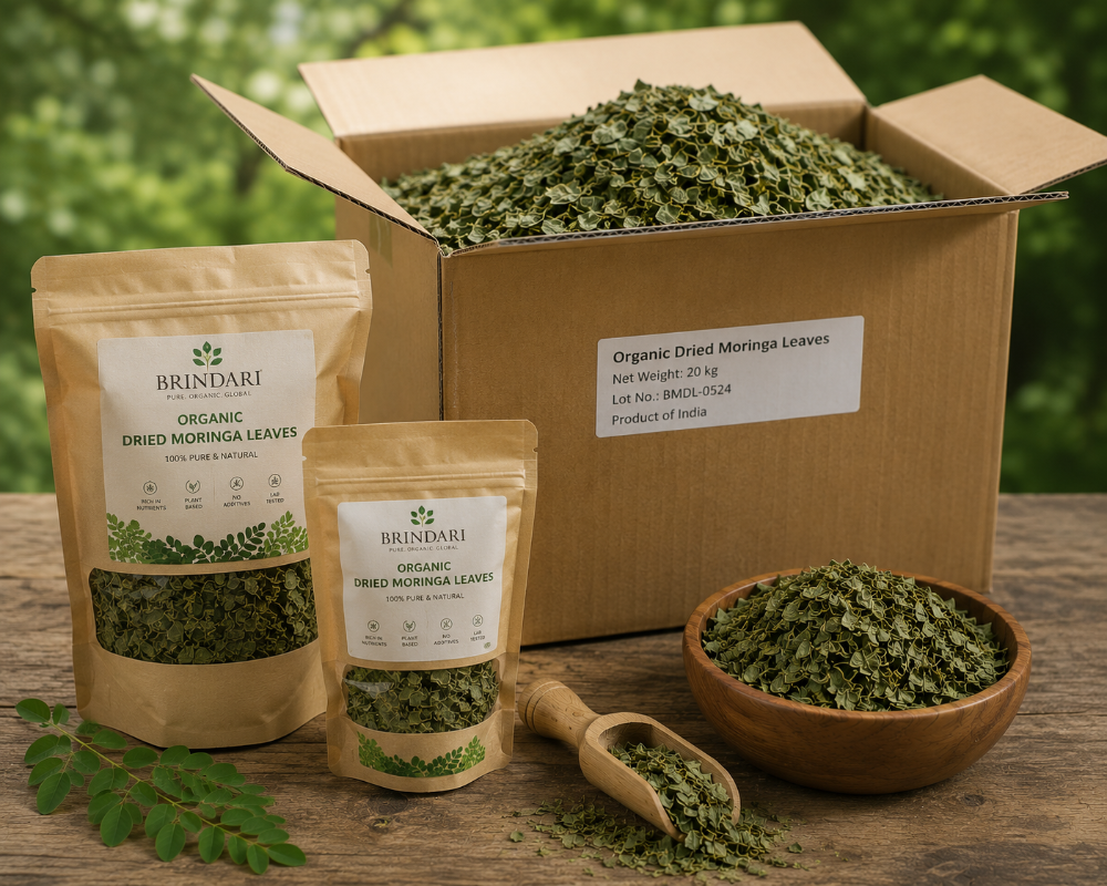 Whole dried moringa leaves in a wooden bowl with kraft pouch and fresh leaves on a farm-side table